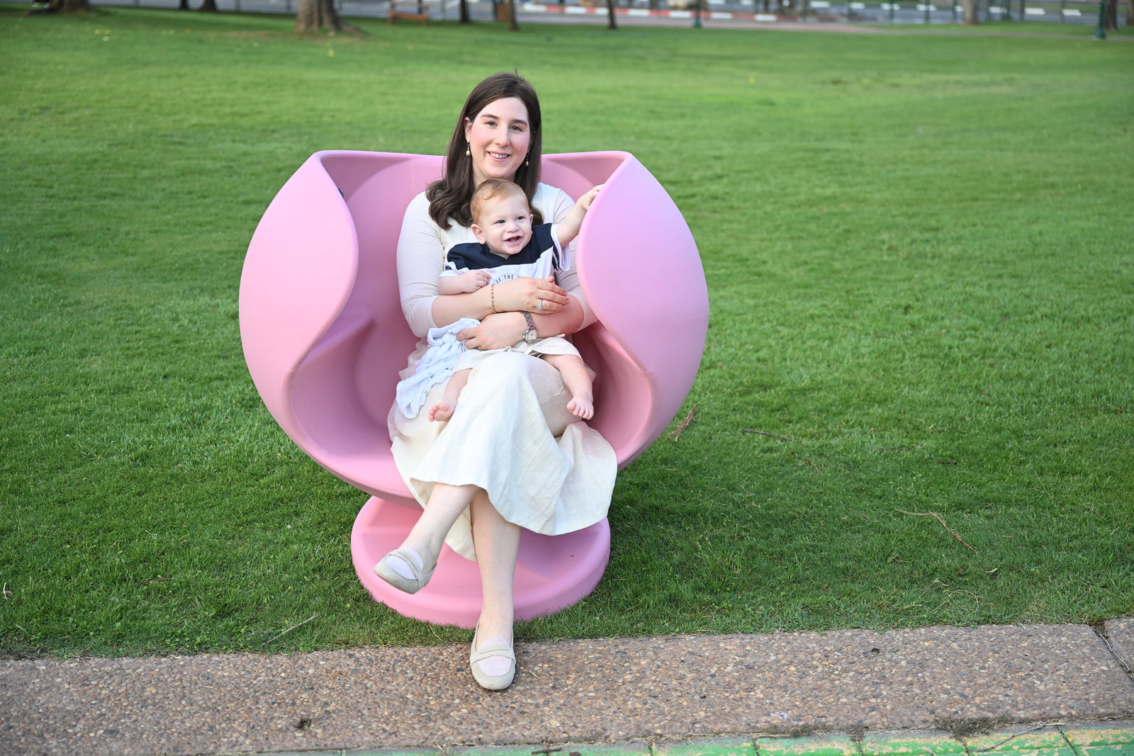 דפנה יושבת עם תינוק בכיסא ההנקה Dafna Chair במרחב הציבורי