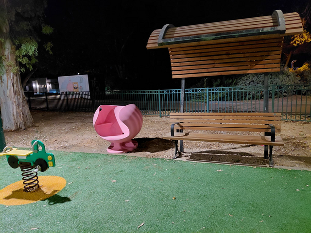 Dafna Chair מותקן בגן ציבורי לצד ספסל עץ
